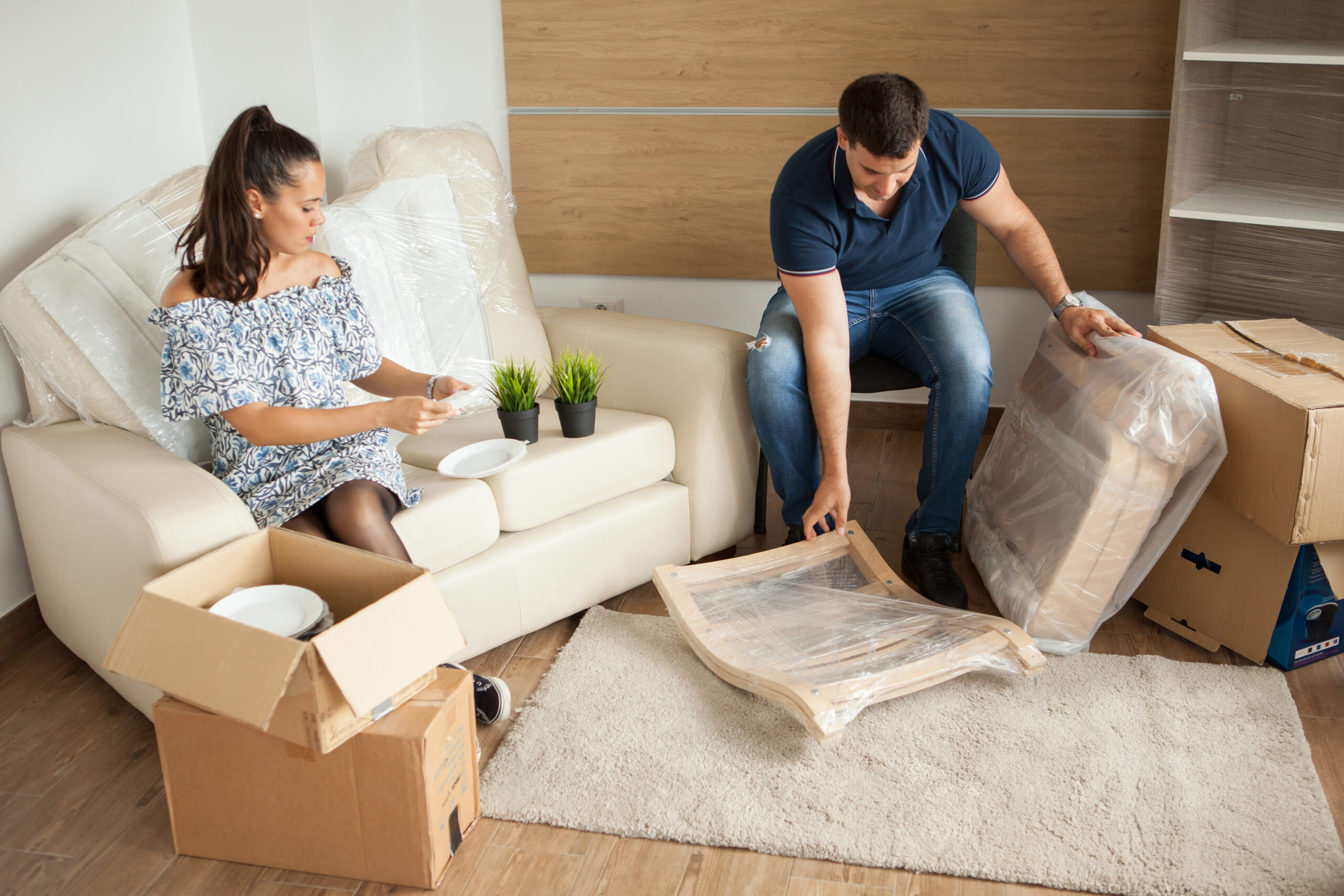 Young couple Moving in new home and unpacking carboard boxes.Almost done moving in.